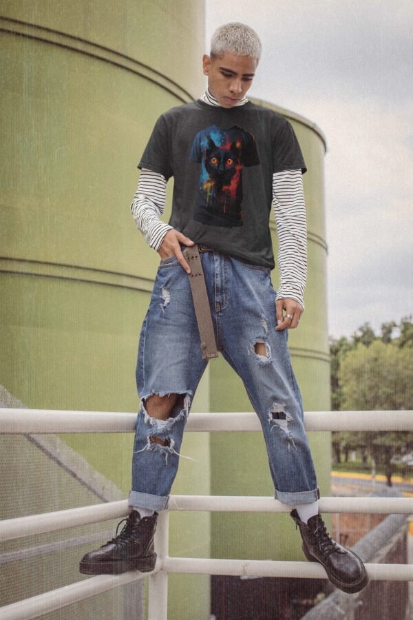 a man in ripped jeans and a t - shirt standing on a rail